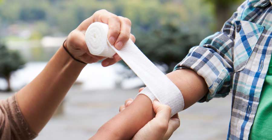 Parent bandaging child's arm